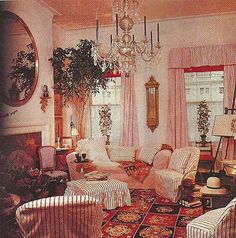 a living room filled with lots of furniture and a chandelier hanging from the ceiling