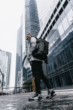 a man walking down the street with a backpack and cell phone in his hand,