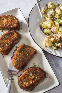 two plates with meat, potatoes and salad on them