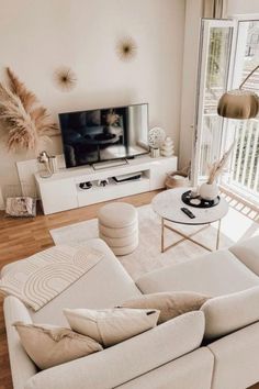 a living room filled with furniture and a flat screen tv on top of a wooden floor