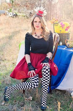 a woman sitting on top of a chair wearing a crown