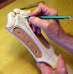 a man working on a wooden shoe with a pencil and sharpener in his hand