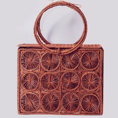 Hand woven bag in iraca palm, designed with a rectangular shape with double handle. Style it with punchy colour combos for a bold and glamorous take on fashion. This product is packaged in an eco friendly box Made in Colombia Available in light brown and navy blue  Composition: Woven Iraca Palm  See-through bag style Dimensions: 9.8 x 7.8 x 3.1 in Bolso tejido a mano en palma de iraca, diseñado con forma de baúl, con aro para sostener con la mano o llevar en el antebrazo. Incluye pañoleta (diseñ Rectangular Vacation Bag With Detachable Handle, Handheld Box Bag For Vacation, Brown Straw Bag With Detachable Handle, Top Handle Straw Bag For Vacation, Brown Jute Bag With Bamboo Handle, Rectangular Crochet Bag With Top Carry Handle For Vacation, Rectangular Crochet Beach Bag With Top Handle, Natural Straw Basket Bag With Detachable Handle, Straw Basket Bag With Top Carry Handle