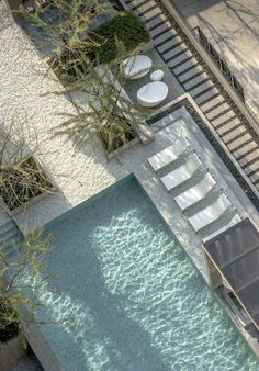 an aerial view of a swimming pool with lounge chairs