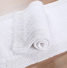 a white towel laying on top of a wooden floor