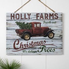 a wooden sign hanging on the side of a wall next to a potted plant