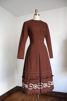 "Lovely brown dress from the 1960s with a really cool white floral embroidered hem. Zipper up the back.  Label: none  Measurements: { small } Bust: 34\"  Waist: 26\"  Hips: 38\" Length: 45\" Sleeve Length: 23.5\" Condition: excellent vintage condition with minor signs of wear - sold as found. washed and ready to wear ☆Shop more☆ http://www.trunkofdresses.com/" 1970s Fitted Brown Dress, Vintage Brown Lined Dress, Fitted Brown 1970s Dress, Fitted Brown 1970s Style Dresses, Vintage Brown Knee-length Dress, Retro Brown Lined Dress, Retro Brown Vintage Dress For Spring, Brown A-line Lined Dress, Brown Knee-length Vintage Dress