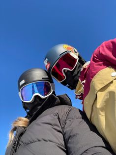 two people wearing ski goggles and jackets