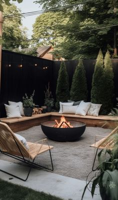 an outdoor fire pit surrounded by chairs and trees