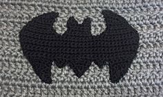 a crocheted batman symbol is shown on the side of a knitted blanket