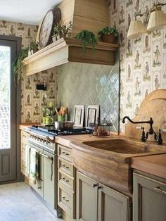 a kitchen with an oven, sink and wallpapered backsplash in the background