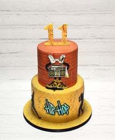 a three tiered cake with graffiti on the top and bottom, decorated with an old school radio