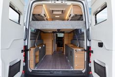 the interior of a van with its doors open and wood flooring in front of it