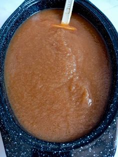 a blue bowl filled with brown liquid on top of a table