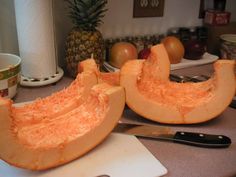 two pieces of melon sitting on top of a cutting board next to a knife