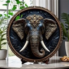 an elephant statue sitting on top of a table next to a potted green plant