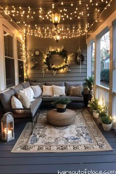 an outdoor living area with lights strung from the ceiling and couches on the porch