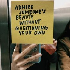 a woman holding up a yellow sign that says admire someone's beauty without gyeeting your own