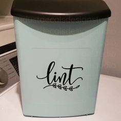 a blue trash can sitting on top of a white counter next to a dryer