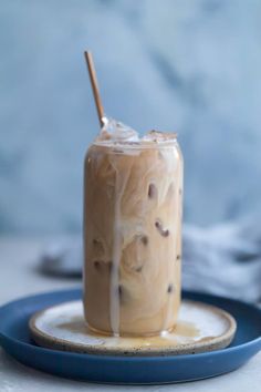 a drink on a plate with a straw sticking out of it's top and another beverage in the background