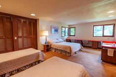 two beds in a room with wooden shutters