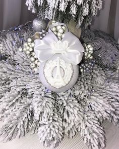 a christmas tree decorated with white and silver ornaments