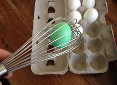 an egg is being whisked by a hand with a beater in it