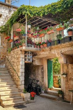 an old building with flowers on the balconies and bikes parked in front of it