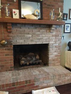 a brick fireplace in a living room with pictures on the mantle and other decorations around it