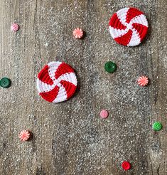 some candy canes and buttons on a wooden surface