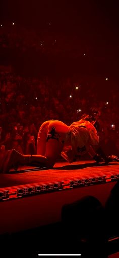 a person laying on the ground in front of an audience