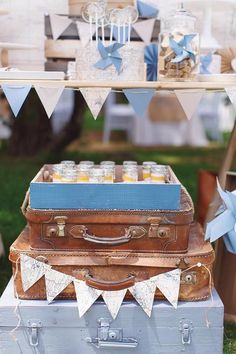 two suitcases stacked on top of each other in front of a table with blue and white decorations