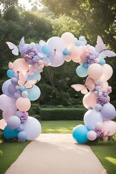 an archway decorated with balloons and butterflies