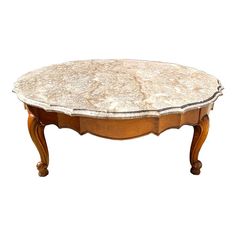 an oval marble top coffee table with wooden legs and carved wood trimming on the edge