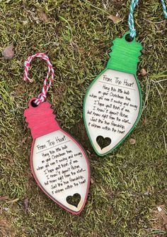 two wooden ornaments with words on them sitting in the grass