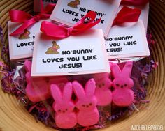 some pink peepies are sitting in a bowl with tags on them that say no bunny loves you like jesus