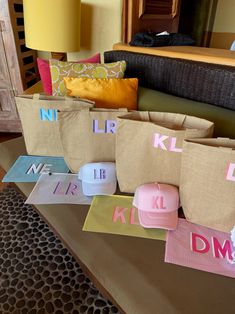 several bags with different letters on them are sitting on a table in front of a couch