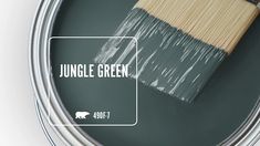 a paint can with the words jungle green painted on it and a brush in front of it