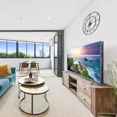 a living room filled with furniture and a flat screen tv on top of a wooden stand