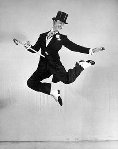 a man in a suit and top hat is jumping