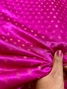 a woman's hand is holding onto a pink fabric