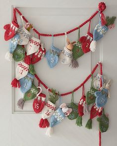 a group of knitted christmas stockings hanging from a string on a white door frame