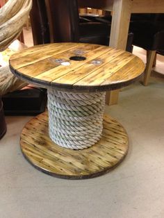 a round wooden table with rope on top