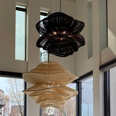 a chandelier hanging from the ceiling in a room with large windows and lots of light