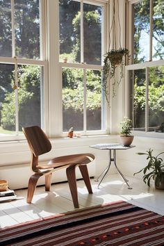 a chair and table in front of large windows