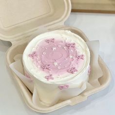 a pink frosted cake in a foam container