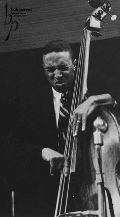 a black and white photo of a man holding a bass