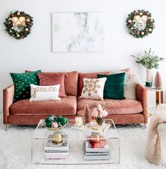 a living room filled with lots of furniture and christmas wreaths on the wall above