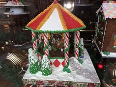 a gingerbread house with candy canes on the roof and decorations all around it