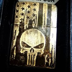 a zippo lighter with a skull on the front and american flag in the back